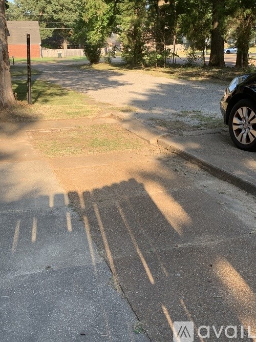 A black car is parked on the side of a street.