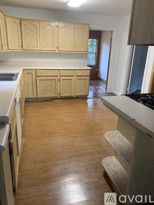 A kitchen with wooden cabinets and a wooden floor.