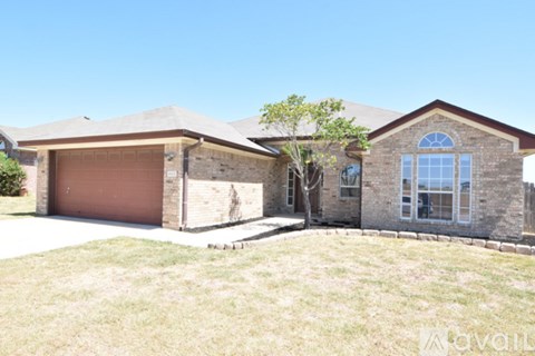 A house with a brown garage door and a tree in front.