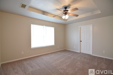 A room with a ceiling fan and a window.