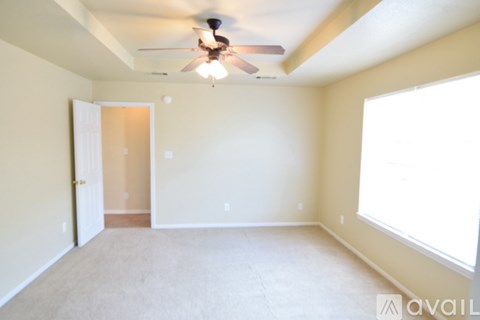 A room with a ceiling fan and a window.