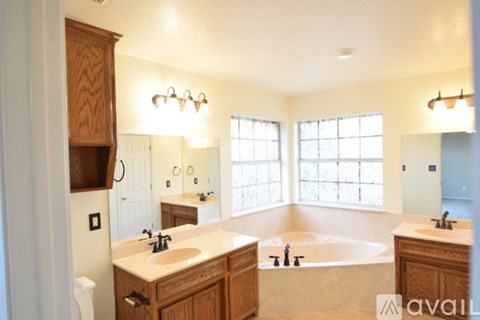 A bathroom with a tub, sink, and mirror.