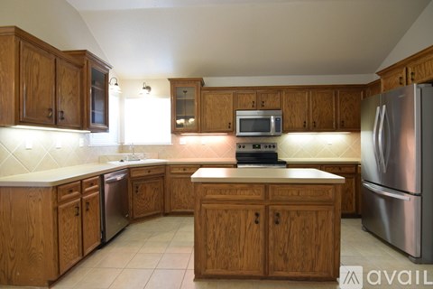 A house with a brown garage door and a tree in front.