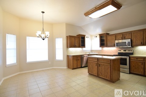 A house with a brown garage door and a tree in front.