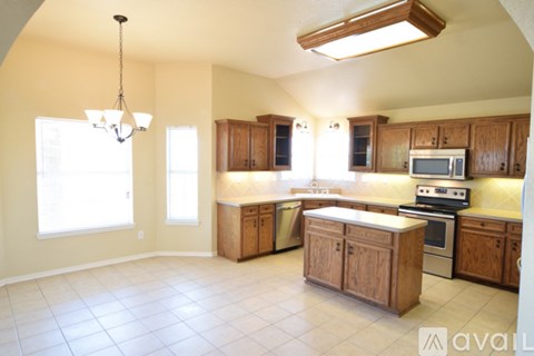 A kitchen with wooden cabinets and a tiled floor.