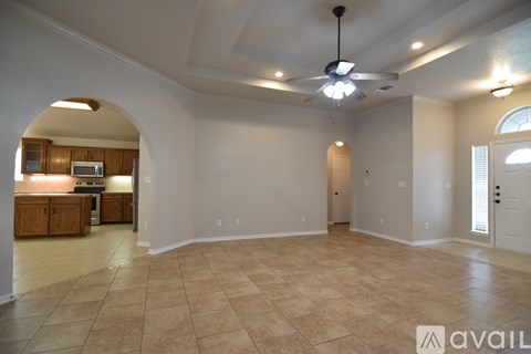 A spacious room with a ceiling fan and tiled flooring.