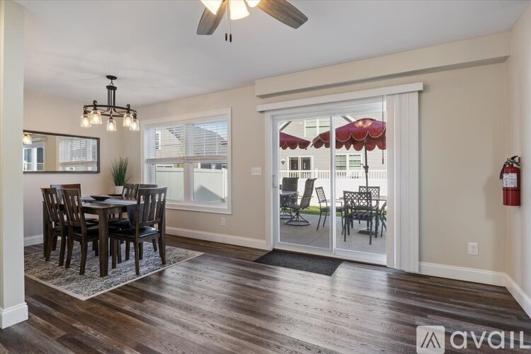 A dining room with a table and chairs and a ceiling fan.