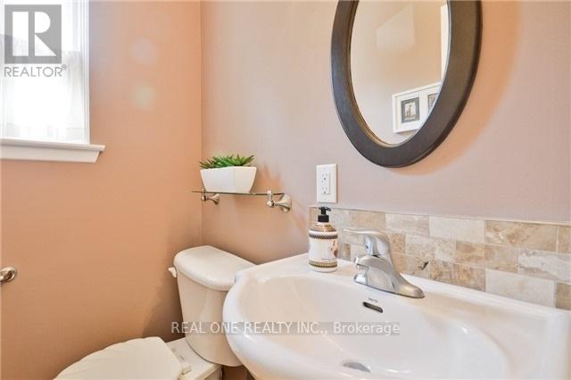 A bathroom with a toilet, sink, and mirror.