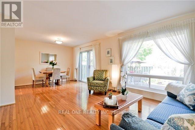 A well-lit, spacious living room with a dining area and a balcony.
