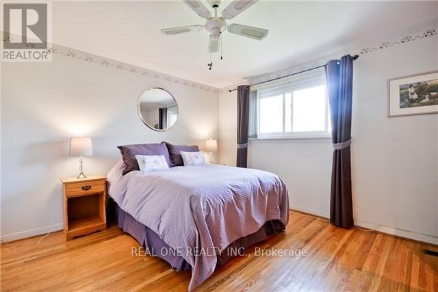 A bedroom with a bed, nightstand, and a ceiling fan.