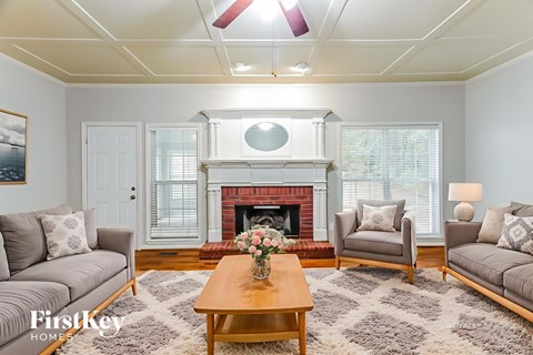 A living room with a fireplace and a painting on the wall.