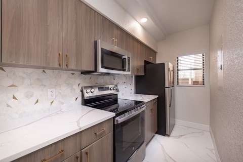 A kitchen with a white counter top and wooden cabinets.