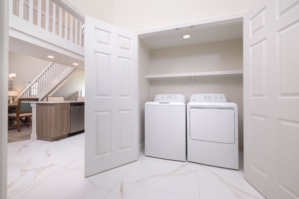 A white laundry room with a washer and dryer.