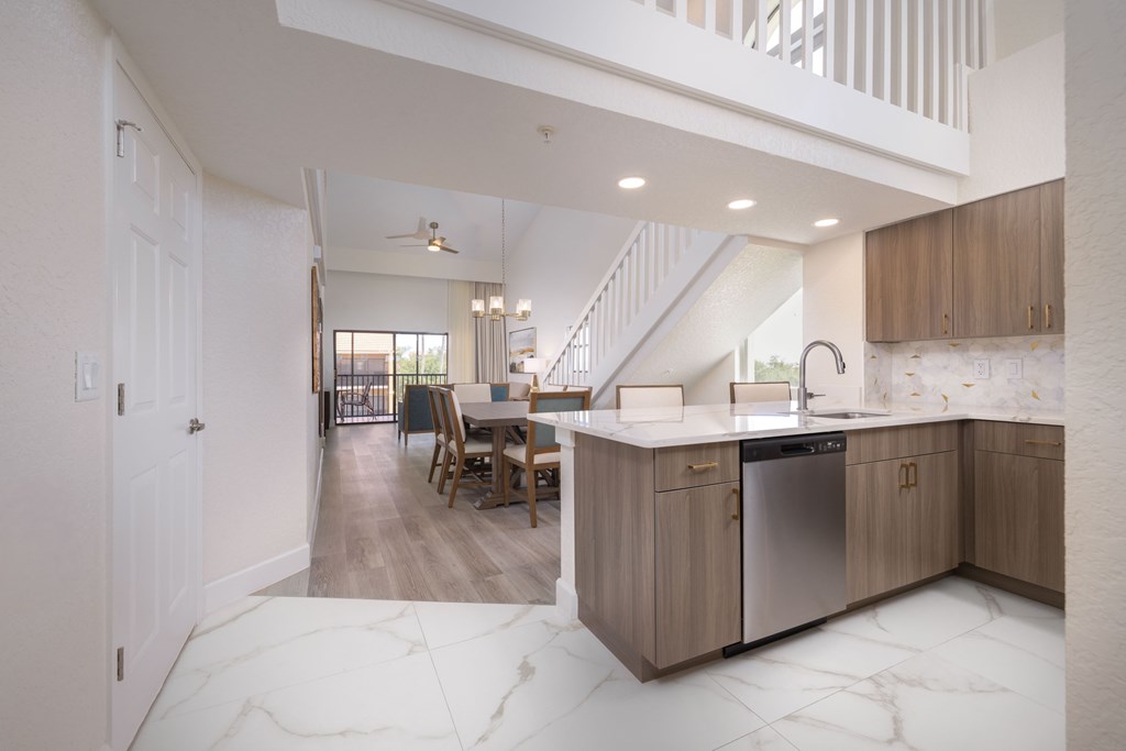 A kitchen with a marble floor and a stainless steel dishwasher.