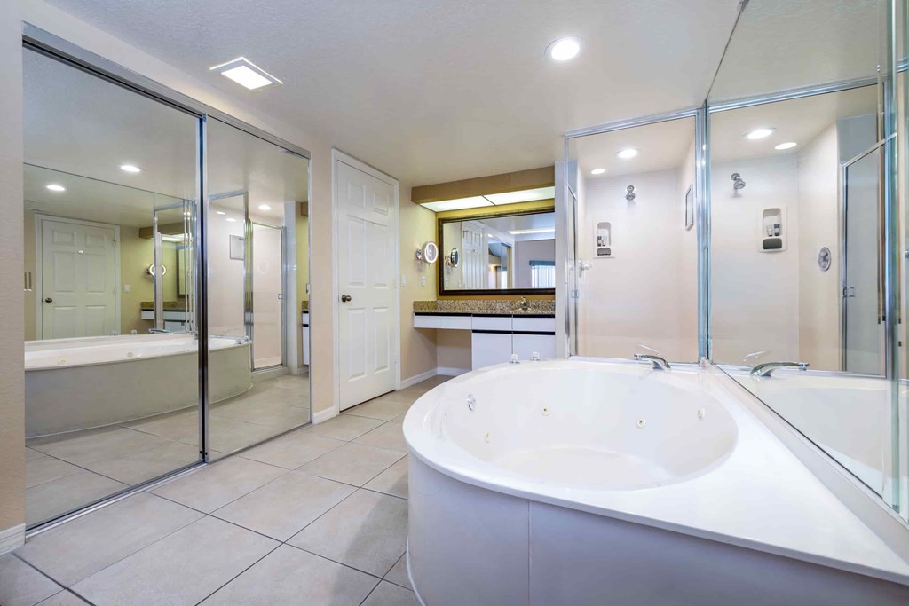A white bathroom with a large tub and a walk-in shower.