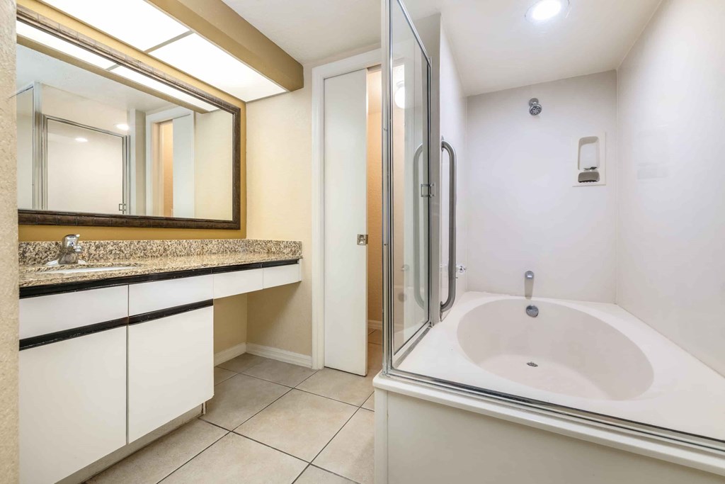 A white bathroom with a sink and a mirror.