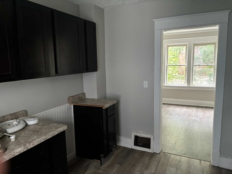 A kitchen with black cabinets and a window.