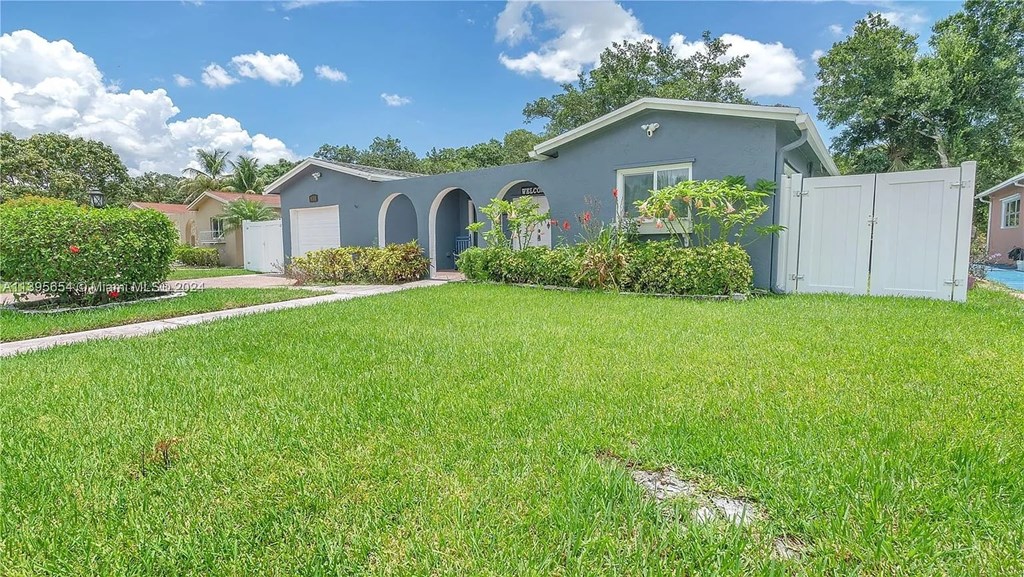 A house with a grey roof and white garage doors.