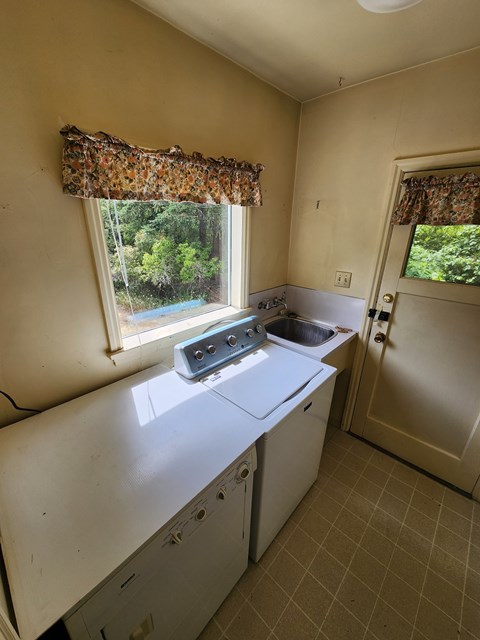 A small laundry room with a washer and dryer.
