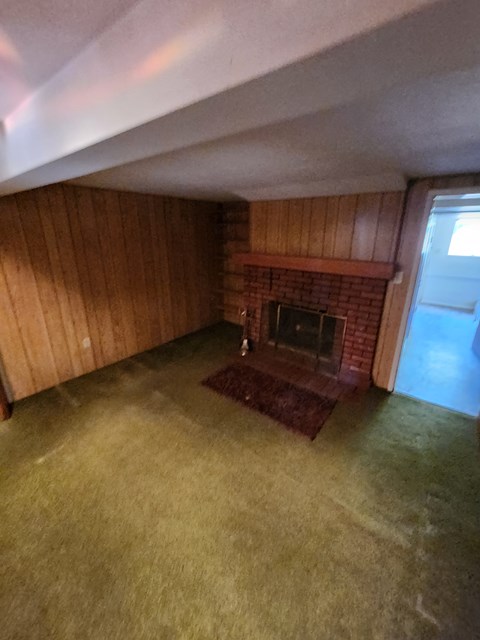 A room with a fireplace and wooden walls.