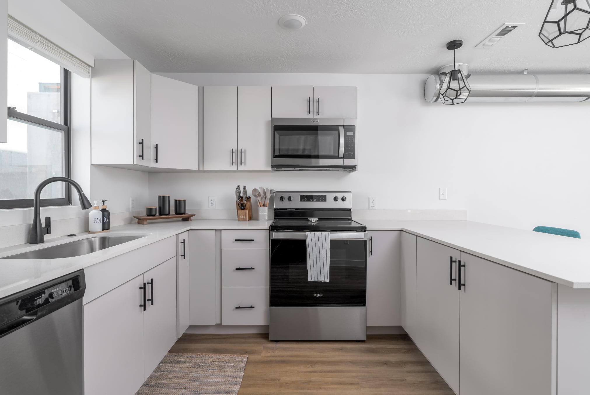 A modern kitchen with white cabinets and stainless steel appliances.