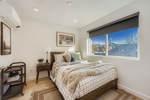 A bedroom with a large bed and a view of a bridge outside the window.