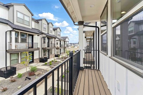 A row of modern townhouses with balconies and black railings.