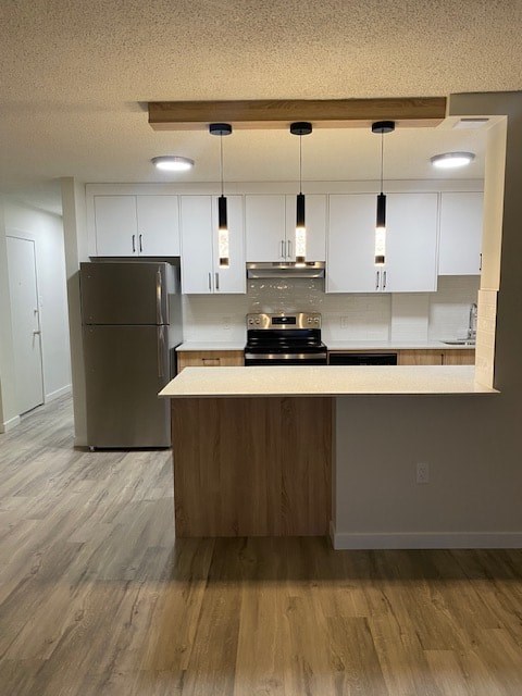 A kitchen with a refrigerator, stove, and island.