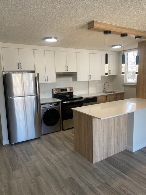 A modern kitchen with a refrigerator, dishwasher, oven, and microwave.