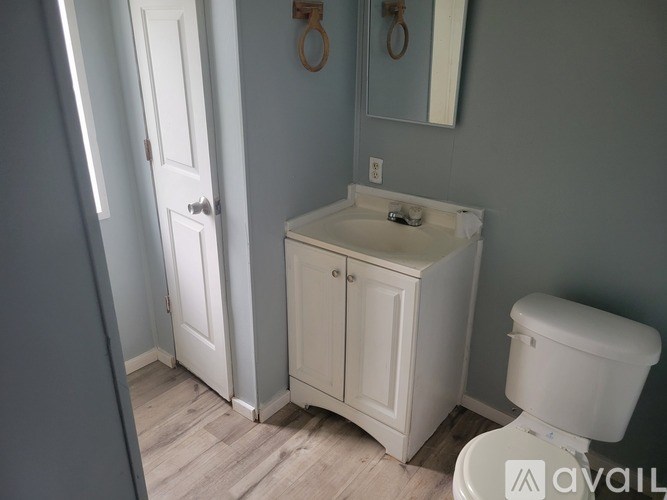 A bathroom with a toilet, sink, and medicine cabinet.