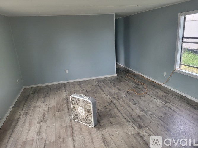 A room with a fan on the floor.