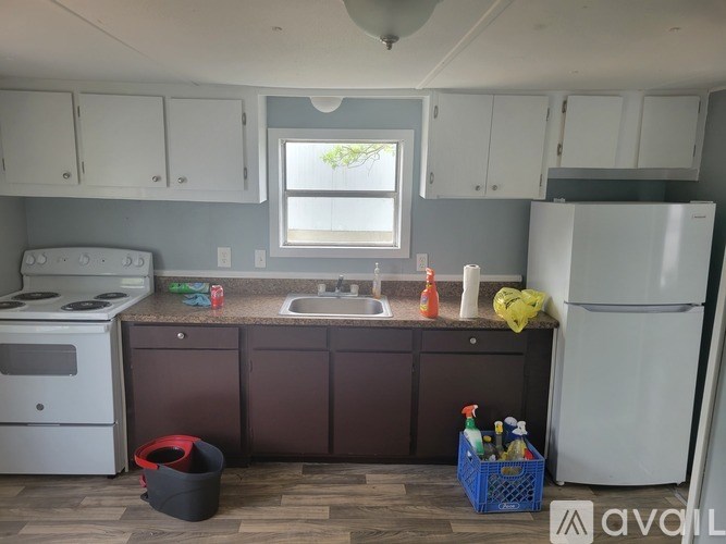 A kitchen with a white refrigerator, a white stove, and brown cabinets.