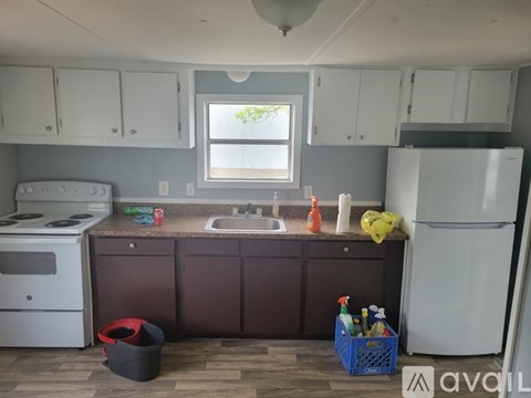 A kitchen with a white refrigerator, a white stove, and brown cabinets.