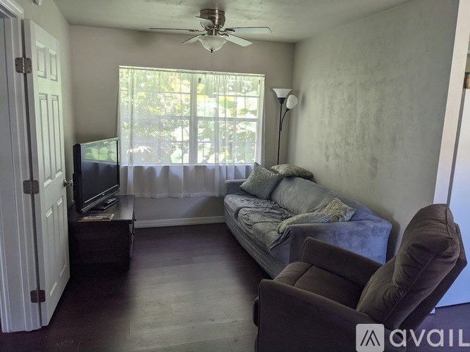 A living room with a brown couch and a television.