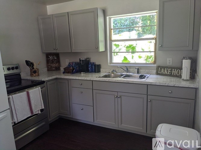 A kitchen with a sink, stove, and cabinets.