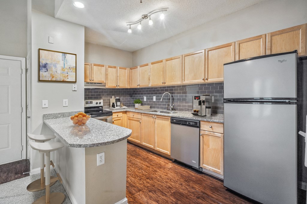 an apartment kitchen with stainless steel appliances and granite counter tops