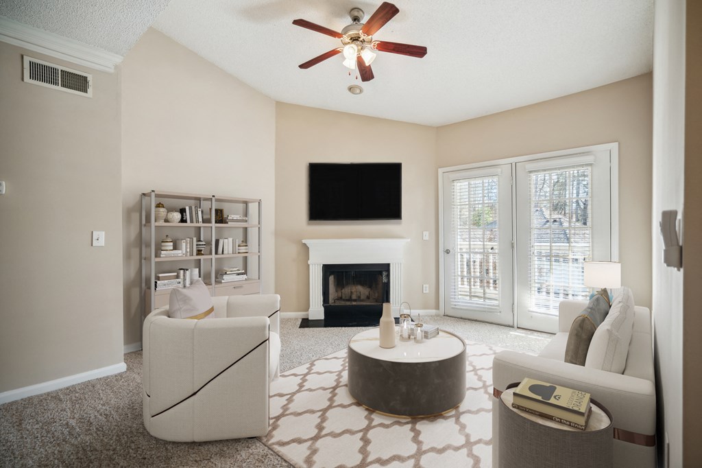 a living room with a fireplace and a ceiling fan