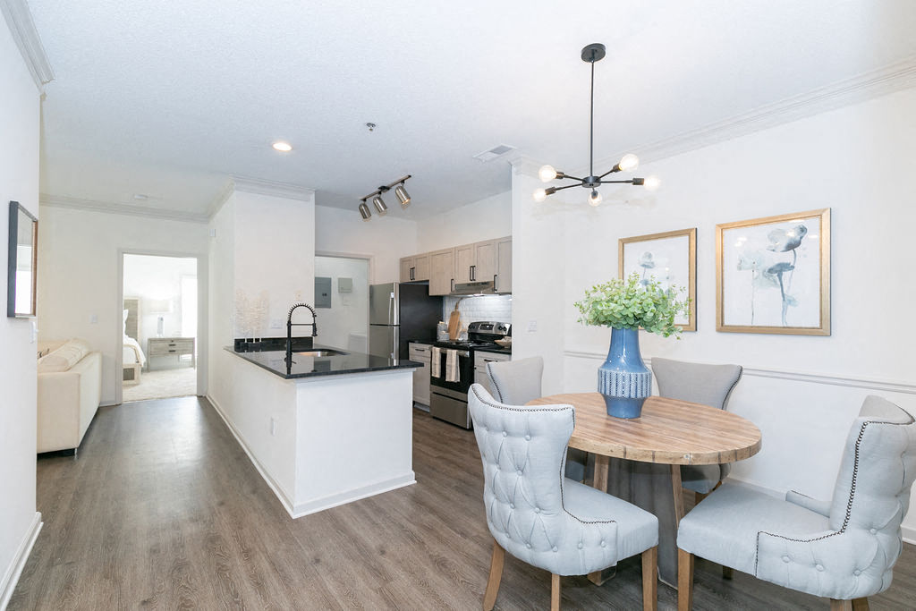 a dining room and kitchen with a table and chairs