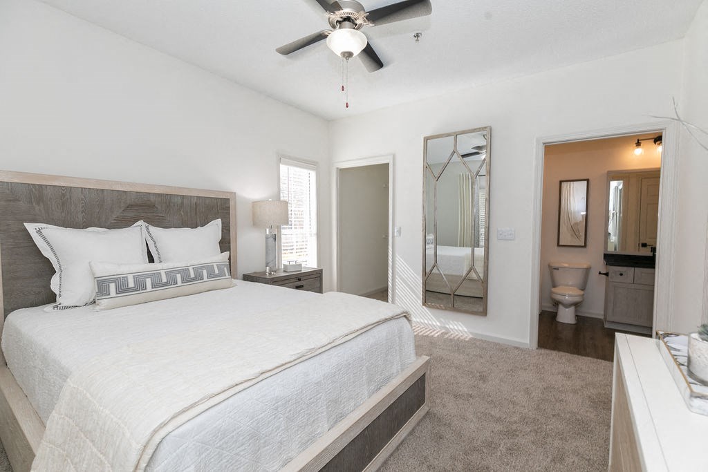 a bedroom with a bed and a ceiling fan