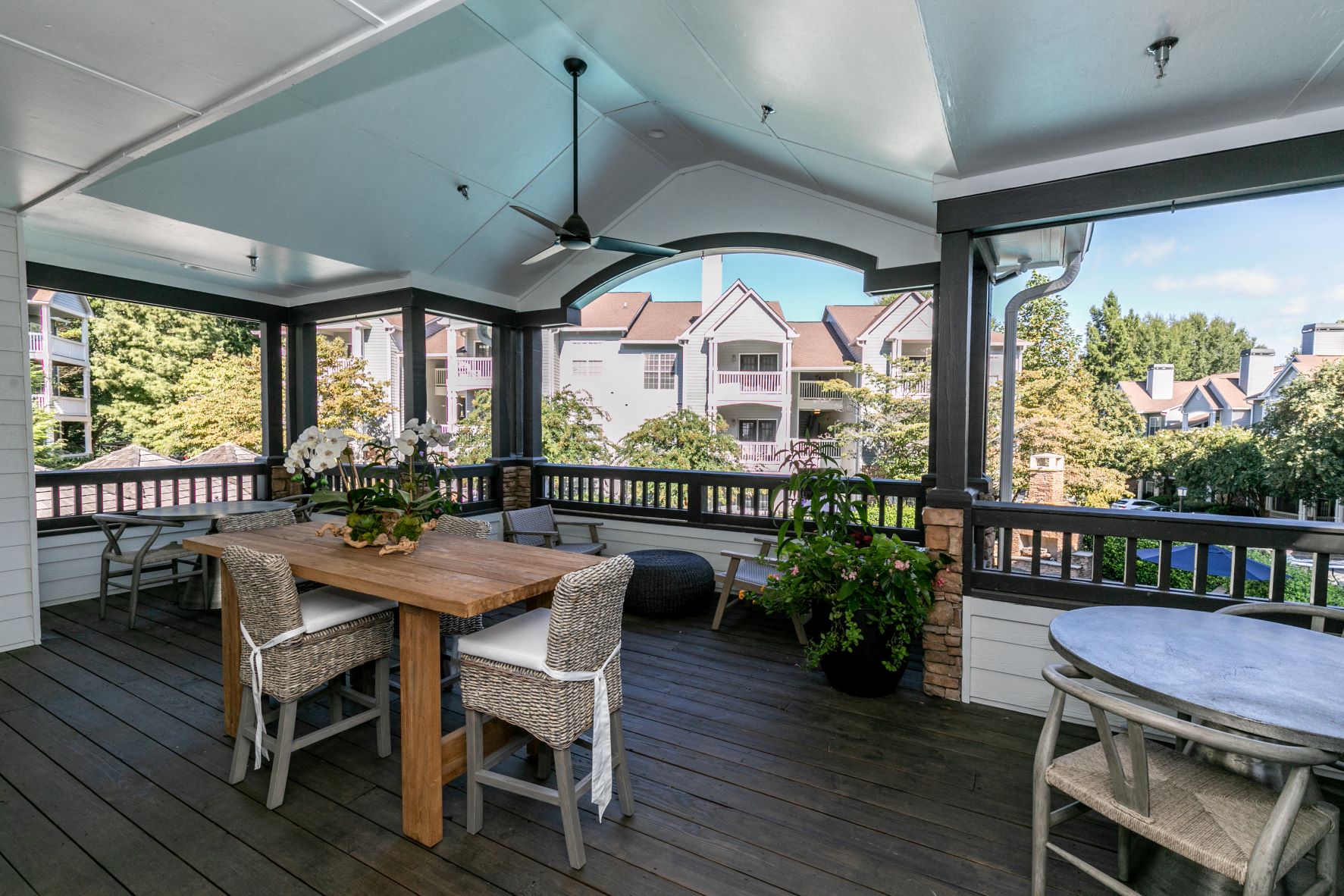 a covered porch with a table and chairs