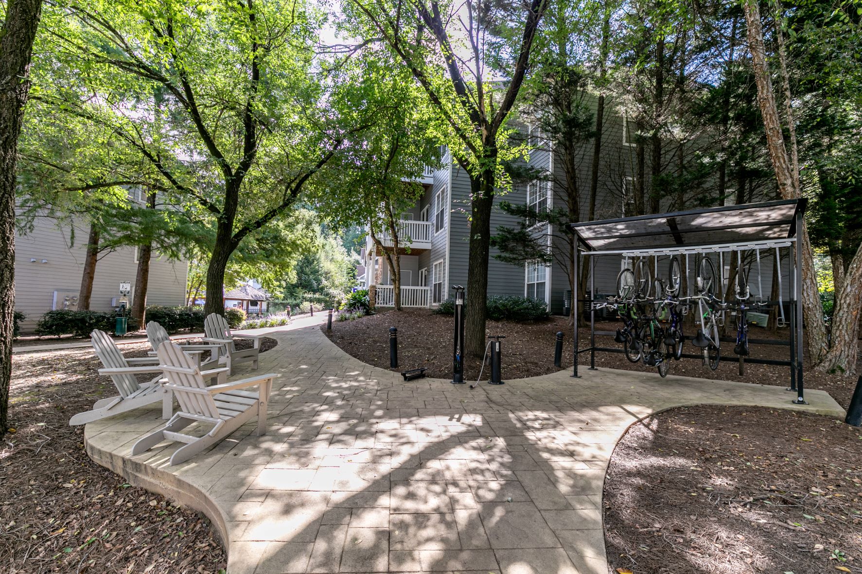 a park with benches and trees in front of a building