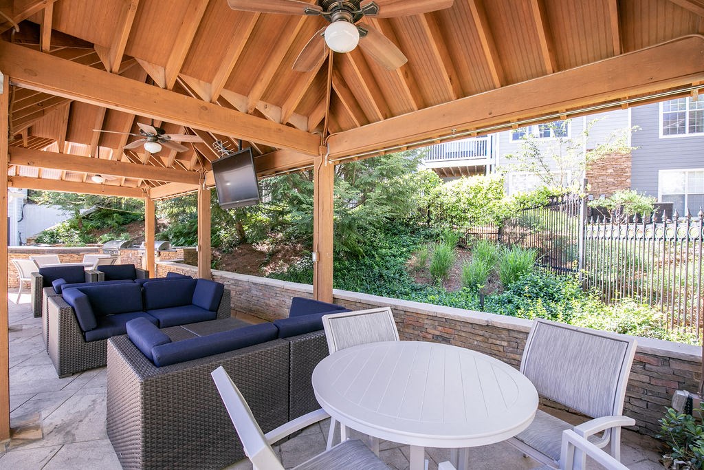 a covered patio with a white table and chairs
