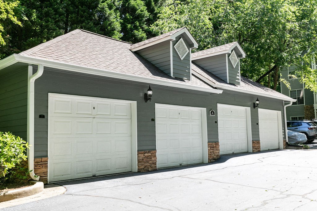 a green garage with two white garage doors