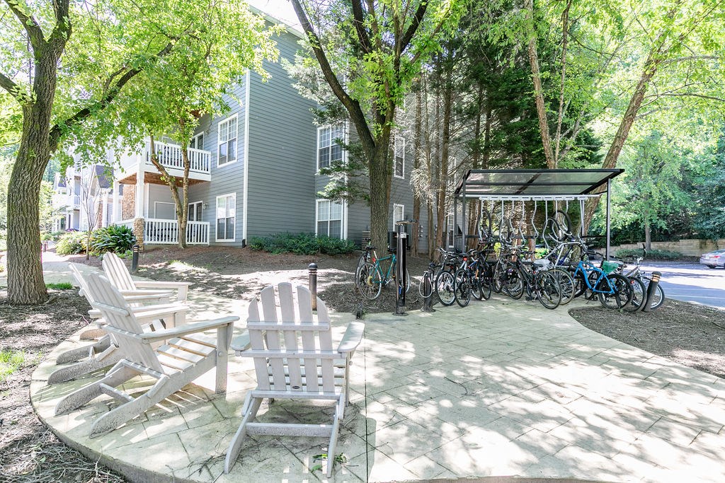 a patio with chairs and bikes parked in front of a building
