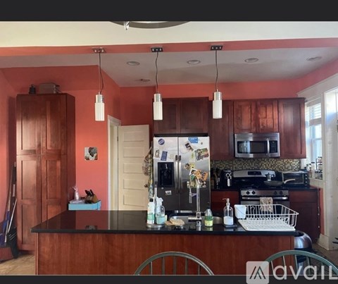 A kitchen with a black counter top and wooden cabinets.