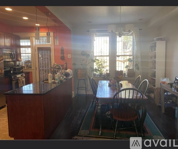 A kitchen with a wooden island and a dining table with chairs.