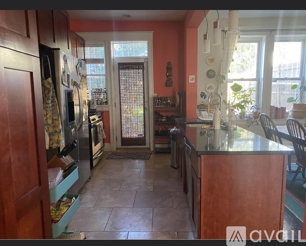 A kitchen with wooden cabinets and a tiled floor.