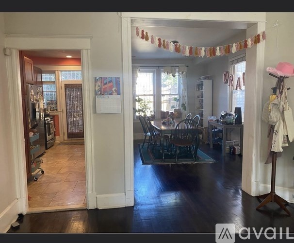 A room with a dining table and chairs in the middle of the room.
