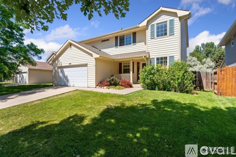 A house with a well-maintained lawn and a clear sky above.