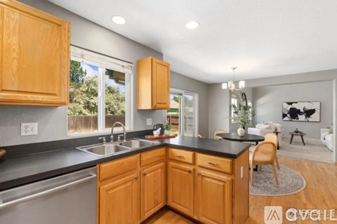 A kitchen with wooden cabinets and a black countertop.